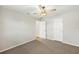 Bright bedroom featuring neutral carpet, ceiling fan, and access to additional rooms at 19897 Midway Blvd, Port Charlotte, FL 33948