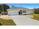 Charming single-story home featuring a two-car garage, and inviting front entrance with well-maintained landscaping at 19897 Midway Blvd, Port Charlotte, FL 33948
