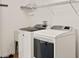 Well-equipped laundry room with modern washer and dryer and convenient shelving at 19897 Midway Blvd, Port Charlotte, FL 33948