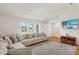 Bright living room featuring hardwood floors and large windows and a comfortable sectional couch at 19897 Midway Blvd, Port Charlotte, FL 33948