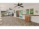 This covered patio features stone floors, ceiling fans, and a view of the pool area at 19897 Midway Blvd, Port Charlotte, FL 33948