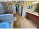 Bright bathroom with dual sinks, soaking tub, shower, and tile flooring at 20940 Valore Ct, Venice, FL 34293