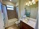 Bathroom featuring a tiled shower, neutral walls, vanity with sink and ample lighting at 20940 Valore Ct, Venice, FL 34293