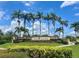 Landscaped entrance to Gran Paradiso with stone signage and palm trees against a clear blue sky at 20940 Valore Ct, Venice, FL 34293
