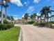 Brick-paved entrance to a gated community, adorned with American flags and lush landscaping, offering a secure welcome at 20940 Valore Ct, Venice, FL 34293