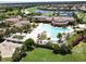 A stunning aerial view of the community pool, featuring sun loungers, umbrellas and crystal clear water at 20940 Valore Ct, Venice, FL 34293