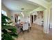Inviting dining space with modern chandelier and seating, with a view of the staircase and living room at 20940 Valore Ct, Venice, FL 34293