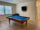 Spacious game room featuring a beautiful pool table, tile floors and a large window for natural light at 20940 Valore Ct, Venice, FL 34293