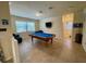 Spacious game room with a pool table, comfortable seating, and natural light, ideal for entertainment at 20940 Valore Ct, Venice, FL 34293