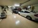 A spacious two car garage featuring overhead lighting, with ample storage space and a clean epoxy floor at 20940 Valore Ct, Venice, FL 34293