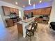 Modern kitchen with granite counters, a breakfast bar, stainless appliances, and wood cabinets at 20940 Valore Ct, Venice, FL 34293