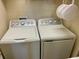 A laundry room with a white GE washer and dryer, ready for your convenience at 20940 Valore Ct, Venice, FL 34293