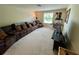 Spacious carpeted living room with a large window, comfortable seating, and entertainment center at 20940 Valore Ct, Venice, FL 34293