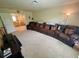 Large carpeted living area with comfortable leather seating, entertainment system, and an open view to upstairs at 20940 Valore Ct, Venice, FL 34293