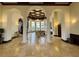 An elegant lobby featuring high ceilings, chandeliers, tile floors, comfortable seating, and a fireplace at 20940 Valore Ct, Venice, FL 34293