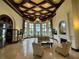 Beautiful lobby boasts coffered ceiling, fireplace, and pool view through large windows at 20940 Valore Ct, Venice, FL 34293