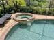 A close up of the jacuzzi attached to the pool, surrounded by a brick deck and greenery at 20940 Valore Ct, Venice, FL 34293