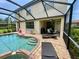 Backyard featuring a screened-in pool with attached jacuzzi, a covered patio and outdoor seating at 20940 Valore Ct, Venice, FL 34293