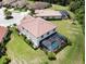 Aerial view of a home with a screened-in pool and lush green lawn within a residential community at 20940 Valore Ct, Venice, FL 34293