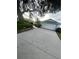Long concrete driveway leading to a two-car garage on a well-maintained property at 2200 E Village Ct, Venice, FL 34293