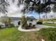 Charming single-story home with lush landscaping, palm trees, and a well-maintained lawn at 2200 E Village Ct, Venice, FL 34293