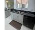 Bright kitchen features gray cabinets, black countertops, stainless steel sink, and modern appliances at 2200 E Village Ct, Venice, FL 34293