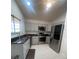 Modern kitchen featuring gray cabinets, stainless steel appliances, and granite countertops at 2200 E Village Ct, Venice, FL 34293