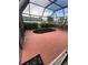 Covered lanai with peach painted floor, garden area, and partial view of the neighborhood at 2200 E Village Ct, Venice, FL 34293