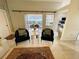 Open living space with tile floors, neutral walls, stylish chairs, and view to lanai at 2200 E Village Ct, Venice, FL 34293