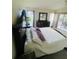 Main bedroom with plush bedding, access to the lanai, and a view of the backyard at 2200 E Village Ct, Venice, FL 34293