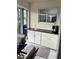 Sunroom features a wet bar with white cabinets, black countertops, and sliding glass windows at 2200 E Village Ct, Venice, FL 34293