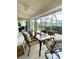 Sunroom featuring tile flooring, ceiling fan, a glass dining table and a backyard view at 2200 E Village Ct, Venice, FL 34293