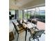Sunroom featuring tile flooring, ceiling fan, a glass dining table and a backyard view at 2200 E Village Ct, Venice, FL 34293
