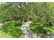 Aerial view of a home showcasing lush greenery, mature trees, and a winding driveway in a tranquil setting at 2237 Circlewood Dr # 18, Sarasota, FL 34231