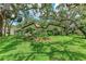Lush backyard with mature trees and tropical landscaping providing shade and privacy at 2237 Circlewood Dr # 18, Sarasota, FL 34231