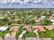 Expansive aerial view of a home with a pool in a lush neighborhood near a lake at 227 Monet Dr, Nokomis, FL 34275