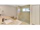 Bright bathroom featuring granite countertops, a glass-enclosed shower, and neutral tile flooring at 227 Monet Dr, Nokomis, FL 34275