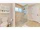 Bright bathroom featuring a glass-enclosed shower and neutral tile flooring at 227 Monet Dr, Nokomis, FL 34275