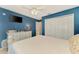 Cozy bedroom featuring a white bed, dresser, mounted TV, and a closet at 227 Monet Dr, Nokomis, FL 34275
