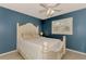Comfortable bedroom featuring white furniture, shuttered windows, and neutral tile flooring at 227 Monet Dr, Nokomis, FL 34275