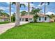 A charming home with a well-manicured lawn and palm trees at 227 Monet Dr, Nokomis, FL 34275