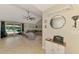 A spacious living room with tile flooring, a ceiling fan, and sliding doors that lead to the pool at 227 Monet Dr, Nokomis, FL 34275