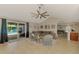 Spacious living room with large sectional sofa, ceiling fan, and sliding glass doors leading to the pool area at 227 Monet Dr, Nokomis, FL 34275