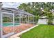 Screened-in pool with patio, garden, and manicured lawn, perfect for outdoor enjoyment at 227 Monet Dr, Nokomis, FL 34275