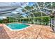 Enclosed pool area with seating, lush green landscaping, and brick patio at 227 Monet Dr, Nokomis, FL 34275