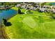 Aerial view of a green putting green surrounded by fairways, ponds, and residential neighborhoods at 2411 New Haven Cir # 70, Sun City Center, FL 33573