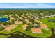 An aerial view of homes nestled within lush green surroundings, bordering a scenic pond at 2411 New Haven Cir # 70, Sun City Center, FL 33573