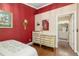 Cozy bedroom with elegant dresser and hardwood floors leads to a bright, adjoining bathroom at 2411 New Haven Cir # 70, Sun City Center, FL 33573