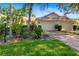 Inviting single-story home featuring a brick driveway and lush, colorful landscaping at 2411 New Haven Cir # 70, Sun City Center, FL 33573