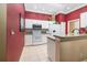 Charming kitchen features red walls, white cabinets, and granite countertops at 2411 New Haven Cir # 70, Sun City Center, FL 33573
